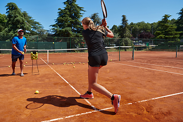 Image showing A professional tennis player and her coach training on a sunny day at the tennis court. Training and preparation of a professional tennis player