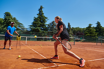 Image showing A professional tennis player and her coach training on a sunny day at the tennis court. Training and preparation of a professional tennis player