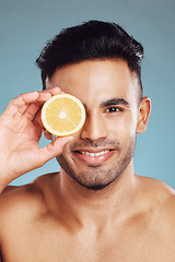 Image showing Skincare, lemon and man in studio for beauty, wellness and cleaning, detox and diet on blue background mockup. Face, fruit and portrait of mexican model happy, smile and relax with vitamin C product