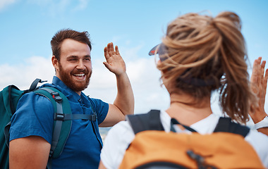 Image showing Couple, high five and hiking for fitness, adventure and exercise in nature while trekking with backpack, happiness and support. Happy man and woman celebrate freedom, travel and holiday in summer
