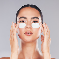 Image showing Face, skincare and woman with eye patches on a gray studio background. Portrait, beauty and model from Canada with facial collagen pads or dermatology product for anti aging, hydration or wellness.