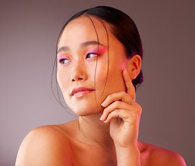 Image showing Beauty, makeup and asian woman with colourful eyeshadow isolated against a studio background. Cosmetics, glowing skin and chinese woman with glamour eye makeup. Smooth and perfect skin after a facial