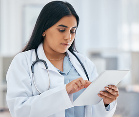 Image showing Health, healthcare and doctor on tablet in hospital working on patient records, researching medicine and planning schedule. Medical professional, female and worker from India on tech browsing web.