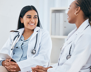 Image showing Diversity, healthcare and doctors talking in hospital, having casual conversation, discussion and chatting. Medical workers, friends and Indian woman with black woman chat, talk and laugh in clinic