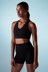 Image showing Fitness, training and a woman serious about health on blue studio background. Thinking, focus and concentration on exercise and motivation to workout with sport model with healthy, fit and slim body