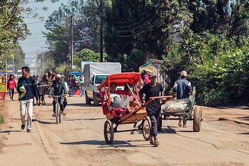 Image showing Traditional rickshaw bicycle with Malagasy people on the street of Antsirabe, one of the ways to earn money. Everyday life on the street of Madagascar.