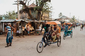 Image showing Traditional rickshaw bicycle with Malagasy people on the street of Miandrivazo, one of the ways to earn money. Everyday life on the street of Madagascar.