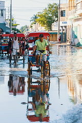 Image showing Traditional rickshaw bicycle with Malagasy people on the street of Toliara, one of the ways to earn money. Everyday life on the street of Madagascar.