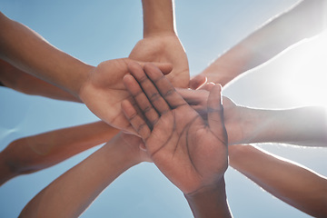 Image showing Hands, team and community below in support, trust or collaboration against a blue sky background. Group hand of people together in teamwork, meeting or partnership for unity, agreement or motivation