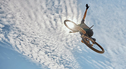 Image showing Cycling jump, blue sky or man on mountain bike does air trick for fun, freedom exercise or training for marathon travel race. Sun flare, extreme sports or athlete cardio workout for action below view