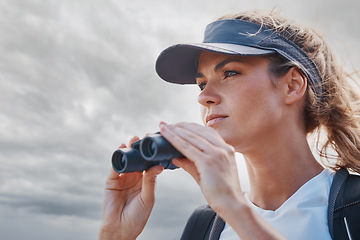 Image showing Woman, binoculars and hiking in nature, travel or outdoors vacation, holiday or trip in Canada. Freedom, cloudy sky and female on adventure, sightseeing or trekking and looking with field glasses.