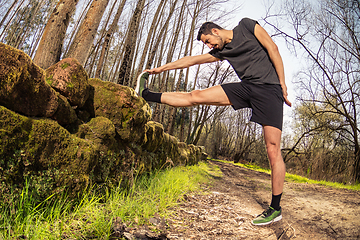 Image showing Male runner stretching outdoors