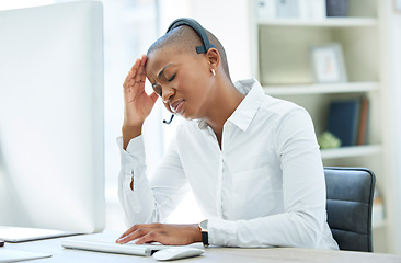 Image showing Black woman, headache and stress in call center by computer for consulting in customer service at the office. African American female suffering from burnout, depression or anxiety in telemarketing