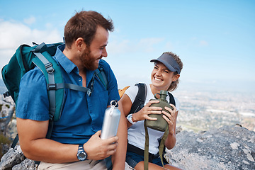 Image showing Hiking, couple and water bottle with smile, conversation and happy together outdoor in nature. Hike, man and woman on mountain range, break, relax and bonding being loving and laugh with fresh air.