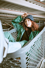 Image showing Fashion, parking lot and shopping cart portrait of woman student relaxing with edgy, trendy and carefree style at mall. City, young and urban fashionista girl in Mexico resting in customer trolley.