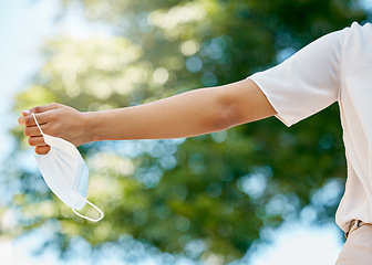 Image showing Freedom, covid and hands with face mask in air at end of pandemic, lockdown and quarantine. Fresh air, happiness and carefree woman holding mask enjoying normal lifestyle in park, outdoors and nature