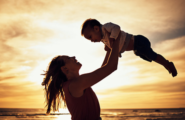 Image showing Family, silhouette and beach sunset with mother and baby against golden sky with love, care and support while on vacation in summer. Woman and child happy by sea for travel, adventure and freedom