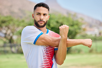 Image showing Fitness, sports and soccer player stretching on a football field in training, exercise and workout in Sao Paulo, Brazil. Focus, warm up and serious athlete ready to start a practice match or game