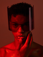 Image showing Cyberpunk, glasses and man in red studio, lighting, model and fashion in the future. Dark, tech and face portrait of male with futuristic, edgy and modern style with visor for cyber punk aesthetic