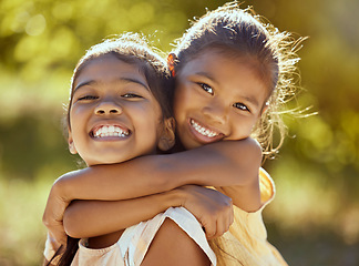 Image showing Girl, hug and love, sisters and happy in portrait together, young kids outdoor and family bonding in nature. Indian children smile, sibling relationship and care, spending quality time in park.