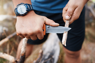 Image showing Hands, knife and cutting with a hiking man carving a stick outdoor in nature while camping for adventure. Wood, weapon and tool with a male camper slicing a twig in the mountains for survival