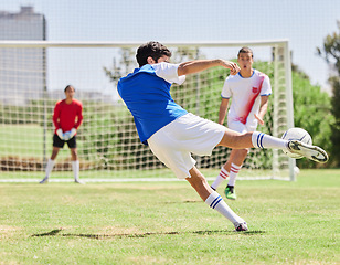 Image showing Sports, soccer and athlete scoring a goal during a match or training on an outdoor pitch at a stadium. Football, fitness and healthy man practicing to score at a game for exercise or workout on field