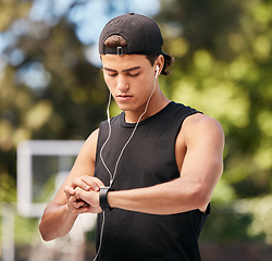 Image showing Fitness, smartwatch and sports man listening to music with earphones and gadget while outdoor for exercise, fitness and training workout. Male with watch to monitor progress, cardio and performance