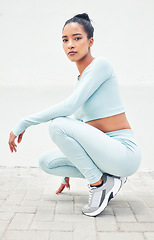 Image showing Fitness, portrait and woman training in the city for health, cardio and a run with fashion clothes for a workout. Sports, exercise and athlete runner against a white wall while running for wellness