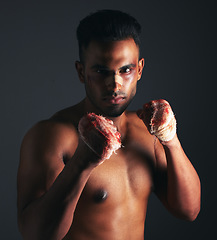 Image showing Fight, bruise and bandage with fighter, blood and injury from mma or boxing against a dark studio background. Strong athlete or boxer portrait with wound on hands and eye from fighting or battle