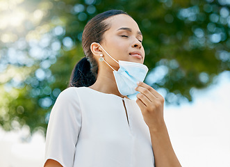 Image showing Covid, take off mask and woman breathing, being calm and peaceful outdoor for break. Healthy female relax, breath and remove face cover for end of corona, pandemic and enjoy fresh air outside freedom