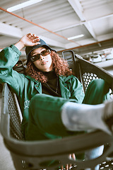 Image showing Fashion, clothes and woman in a shopping cart for urban aesthetic in the city of Los Angeles. Supermarket, portrait and fashion model with trendy, stylish and designer sunglasses in road or street