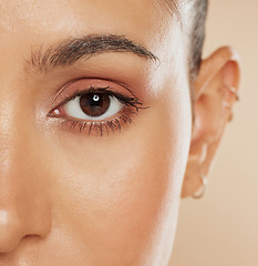 Image showing Eye, vision and beauty with a model woman closeup in studio on a beige background for eyecare or skincare. Zoom, cosmetics and wellness with a female posing to show her eyelash, eyebrow or pupil