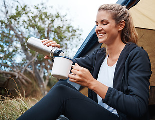 Image showing Camping, coffee and woman in nature by tent on vacation, holiday or trip. Tea, travel and female camper from Canada relaxing in woods, forest or grass field while pouring hot beverage from bottle.