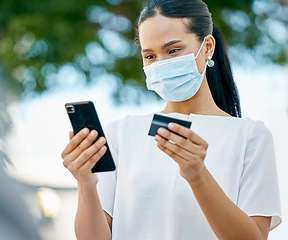 Image showing Covid, phone and woman in face mask with a credit card for a payment or to send cash on a digital application. Coronavirus, finance and healthy girl customer busy online shopping and money transfer