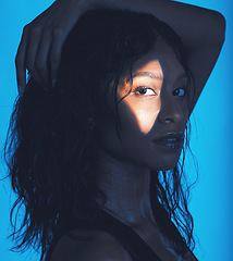 Image showing Face, light and woman in studio for skincare, beauty and wellness against a blue background mockup. Portrait, spotlight and girl model from Mexico in pamper, moisture and hydration spa skin treatment