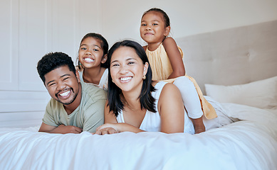 Image showing Happy family with kids, smile and lying on bed in home, portrait of mother, father and children together in Asia. Love, fun and family time for dad, mom and daughters in family bedroom in Indonesia.