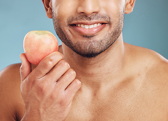 Image showing Face, skincare and man with apple for health, vitamin c and nutrition on blue studio background. Wellness, healthy lifestyle or bearded model holding fruit for minerals, natural skin or facial care