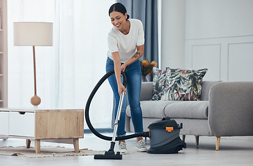 Image showing Black woman vacuum cleaner, smile in living room and cleaning tiles floor in home for hygiene. Woman cleaner, happy with appliance for housekeeping work on flooring in house for dust or dirt indoors