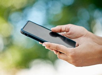 Image showing Mockup, phone and closeup of hands in nature with blank, empty and black screen. Technology, communication and person holding smartphone in outdoor park for social media, internet and mobile app