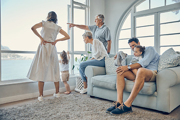 Image showing Travel, family and window in a living room of holiday house, bonding and relax while enjoying the view together. Vacation, home and happy family with kids, parents and grandparents and scenic view