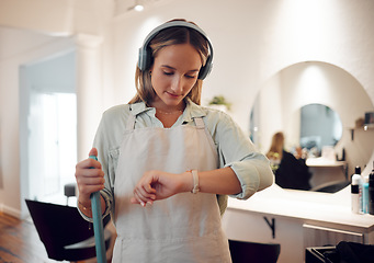 Image showing Watch, headphones and woman cleaning salon while streaming music, podcast or radio. Break, cleaner and female from Canada sweeping workplace, looking at time and listening to audio, song or album.