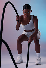 Image showing Rope, cardio and woman training for health, fitness and wellness against a colourful studio background. Strong, focus and Indian athlete with battle ropes for exercise, motivation and workout