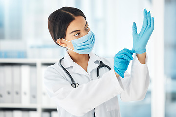 Image showing Healthcare, covid and a doctor putting gloves on hands, woman ready for check up examination or surgery in hospital or clinic. Safety, protection and lady medical worker with surgical face mask.