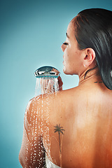 Image showing Beauty, skincare and woman in a shower for grooming, hygiene and hair against a blue background. Water, cleaning and girl in water splash for wellness, routine and skin, self love and studio pamper