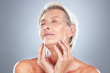 Image showing Senior woman, relax and beauty for skincare, cosmetic or facial treatment against a grey studio background. Happy elderly female hands touching face in satisfaction for perfect skin, glow or makeup