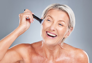 Image showing Happy, senior woman and makeup brush in studio for beauty, skincare and wrinkles treatment on a grey background. Face, cheek and product by elderly model happy, excited and smiling about cosmetics