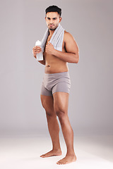 Image showing Portrait, water bottle and man with towel isolated on gray studio background. Fitness, wellness and healthy athletic male from India ready for hydration after training, exercise or workout mock up.