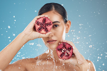 Image showing Beauty, health and skincare of woman with pomegranate, water splash and blue studio background. Wellness, healthy lifestyle or female model from Canada with fruit for vitamin c, nutrition or minerals