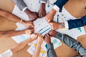 Image showing Teamwork, documents and circle of hands in fist in business meeting for strategy, planning and analytics. Collaboration, diversity and business people with paperwork, infographics and graphs on desk