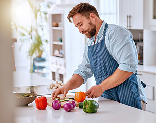 Image showing Man, chef and cooking, cut vegetable in kitchen and healthy with diet, nutrition and vitamins preparing dinner or lunch meal. Food at home with apron and organic, fresh pepper and onion.